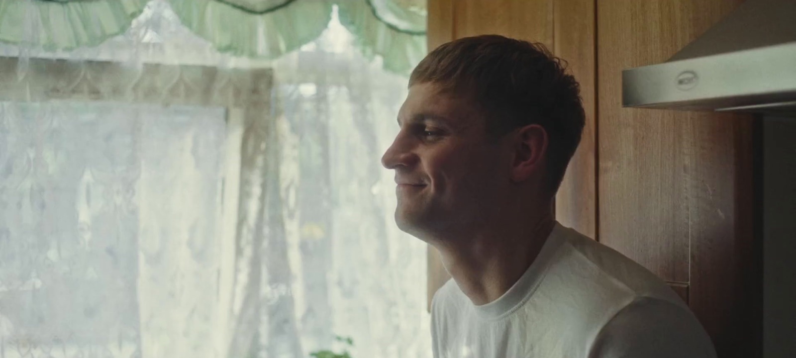 a man standing in front of a window in a kitchen