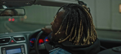 a man with dreadlocks driving a car