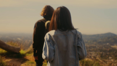 a man and a woman standing on top of a hill