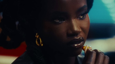 a woman is eating something while wearing gold hoop earrings