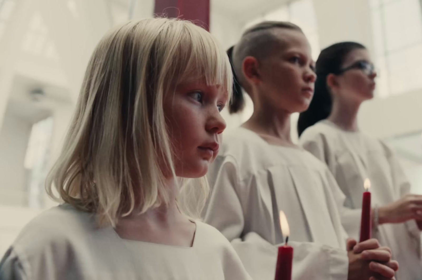 a group of women standing next to each other holding candles