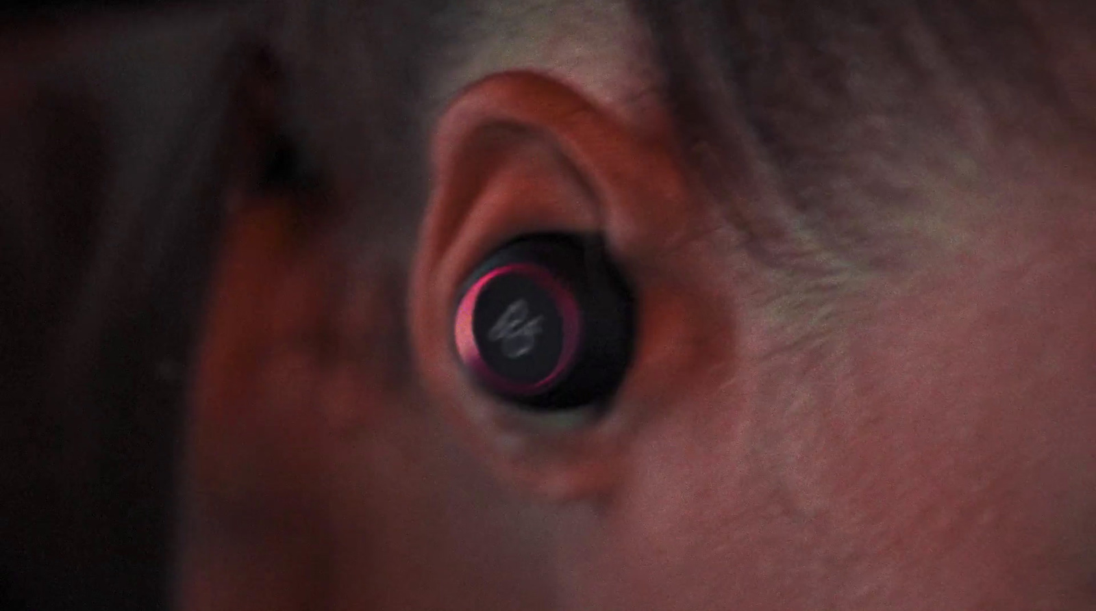 a close up of a person's ear with a pink ring