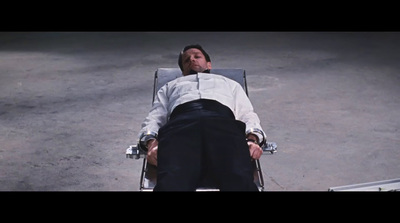 a man in a white shirt and black pants laying on a chair