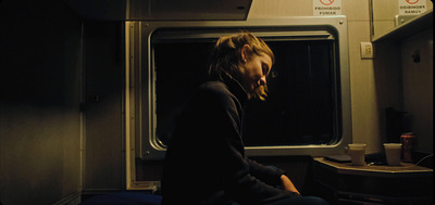 a woman sitting on a train looking at her phone