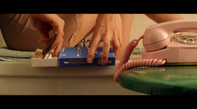 a woman is using a pink phone on a table