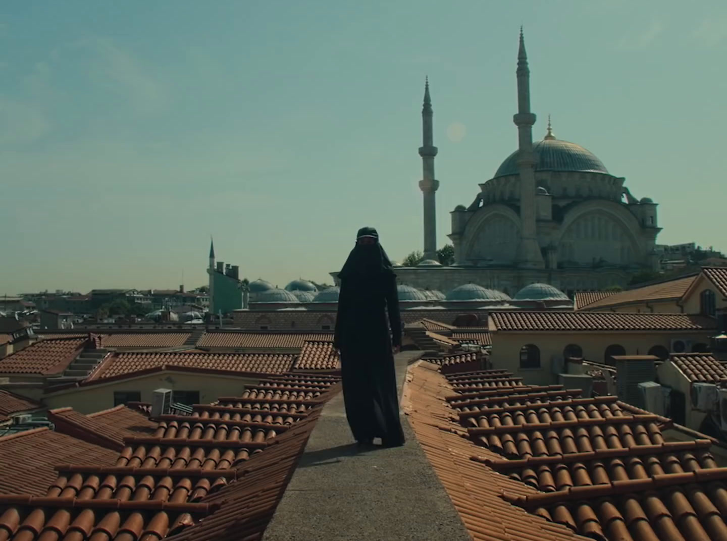 a person standing on a roof with a building in the background