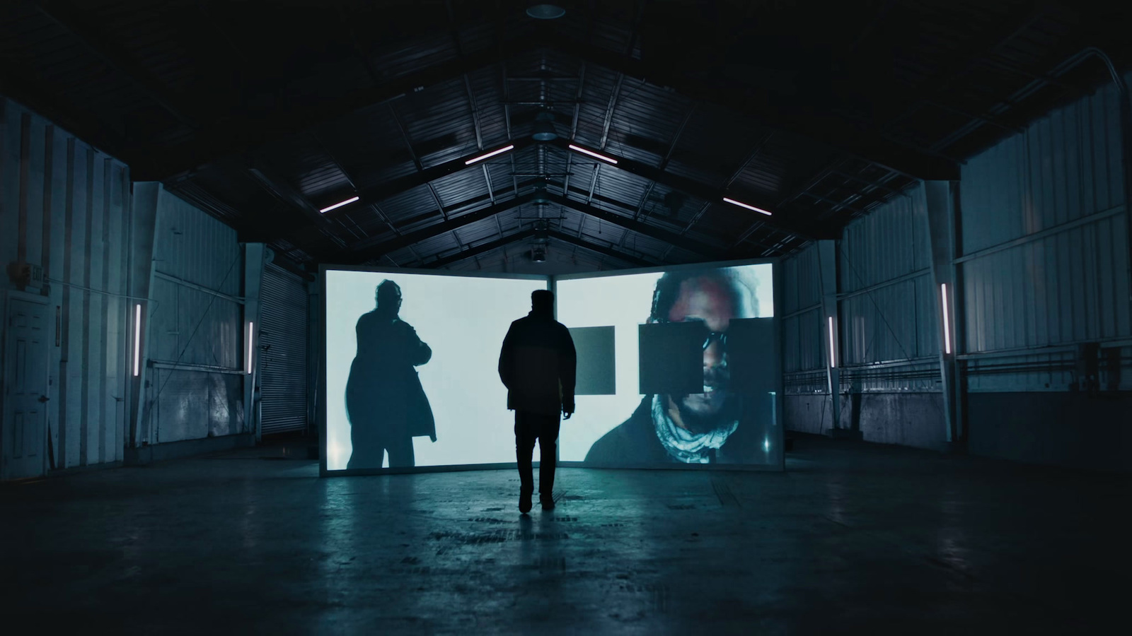 a man standing in front of a large screen