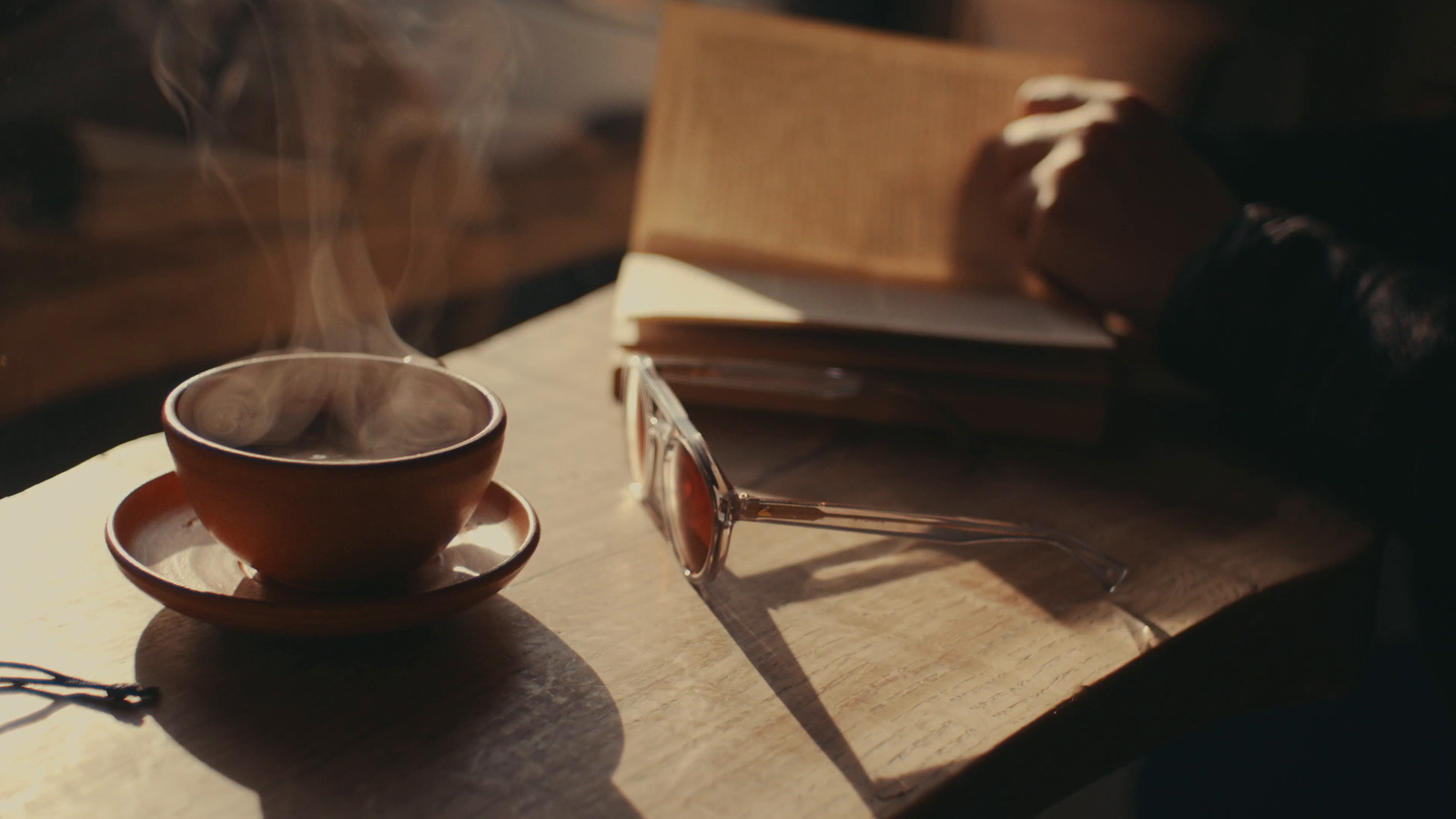 a cup of coffee sitting on top of a wooden table