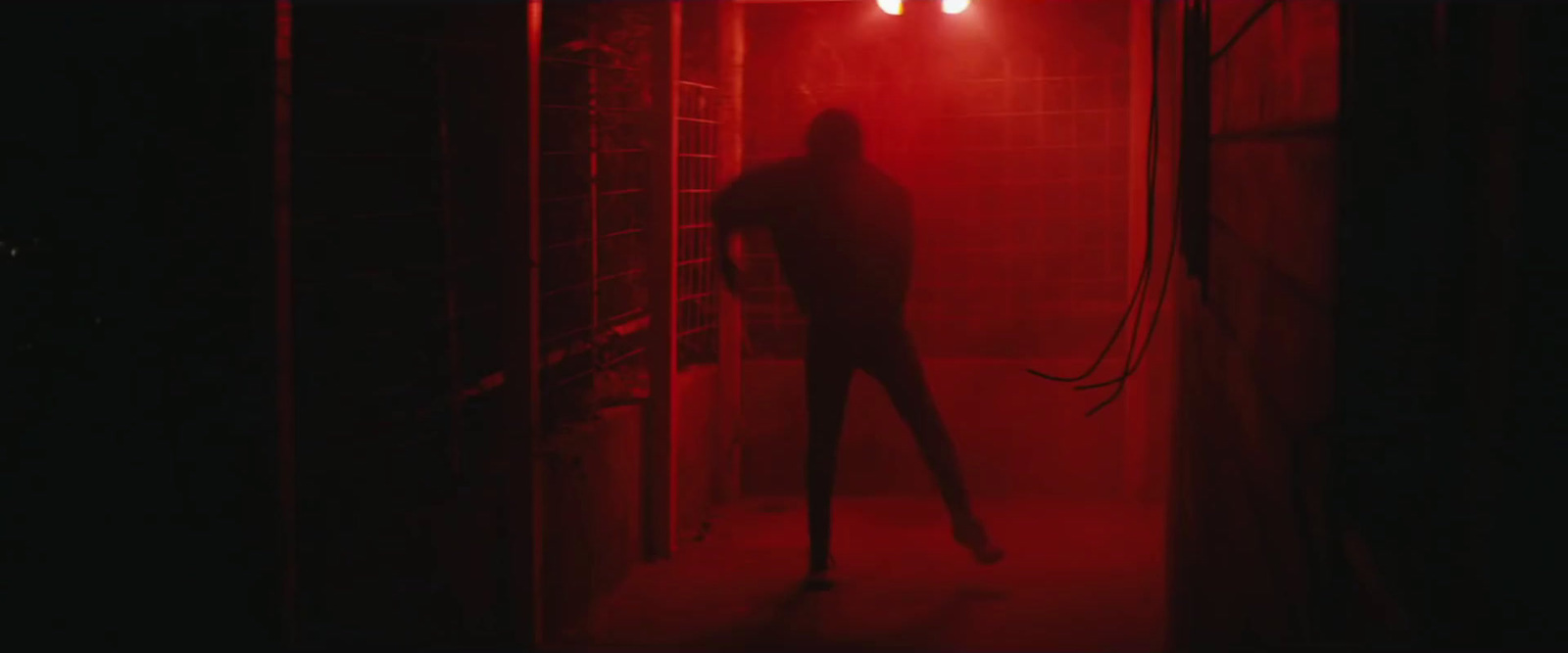 a woman standing in a dark room with a red light