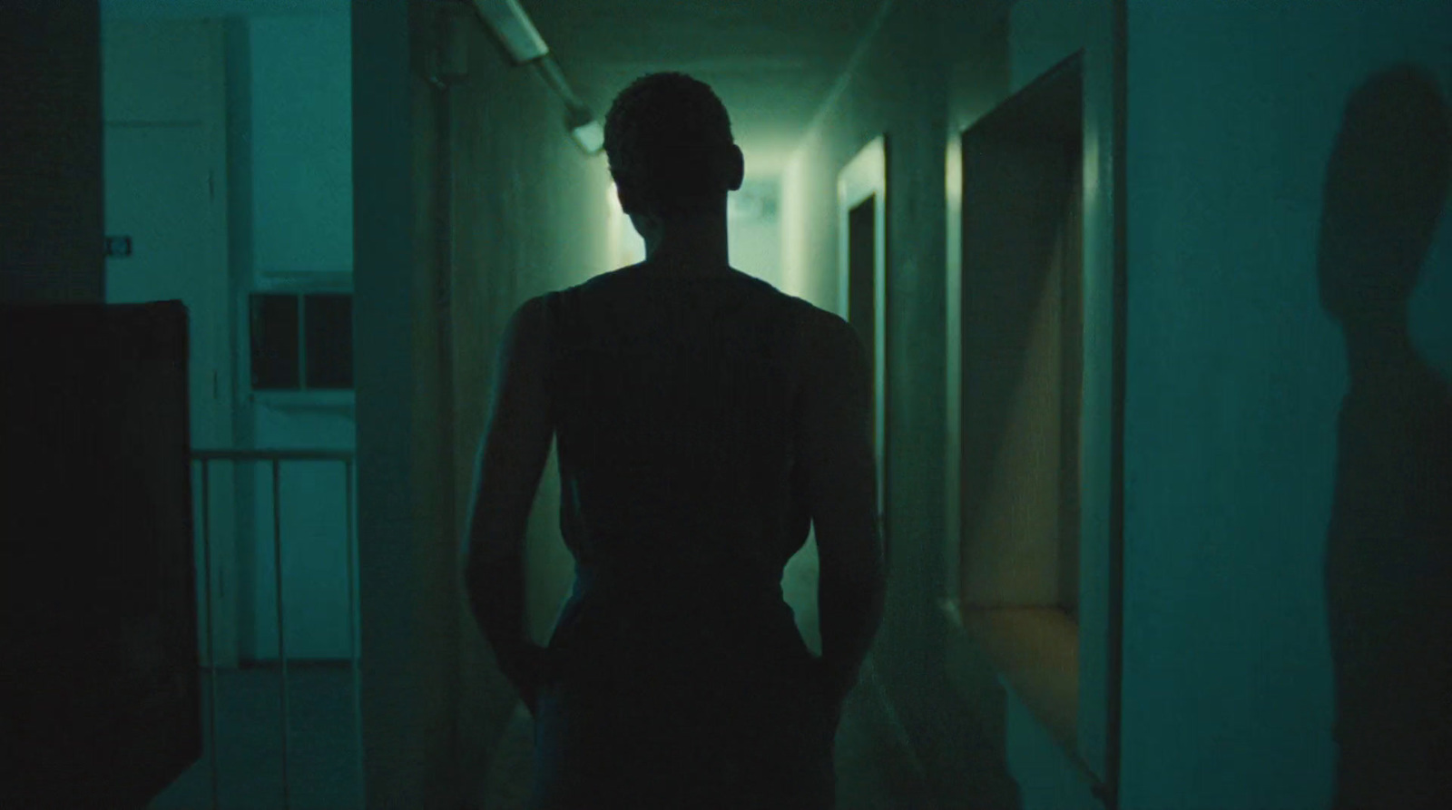 a person standing in a hallway in the dark