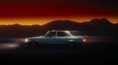 a car driving on a road with mountains in the background