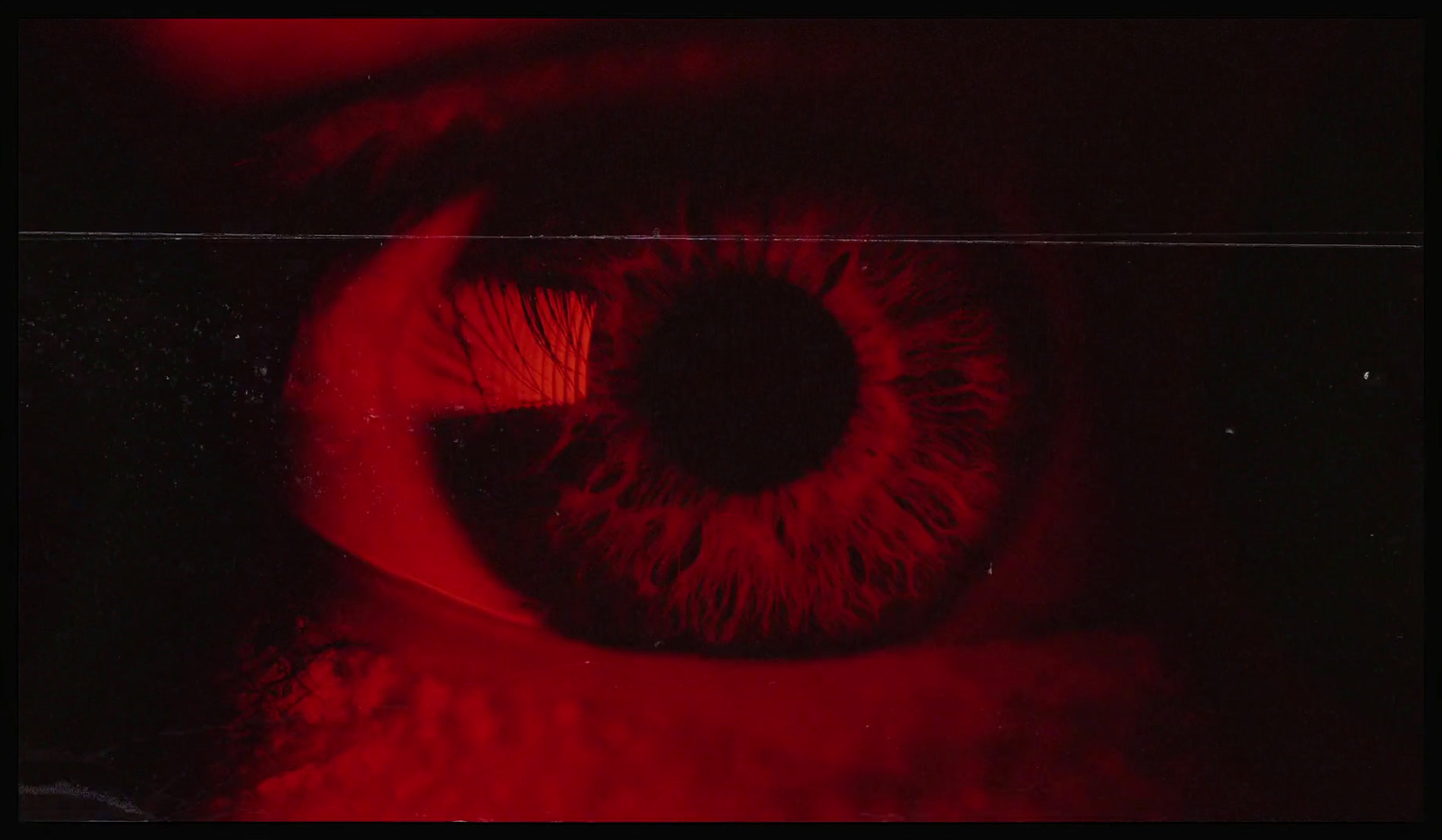 a close up of a red eye in the dark