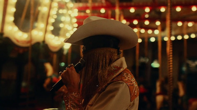 a man in a cowboy hat holding a microphone