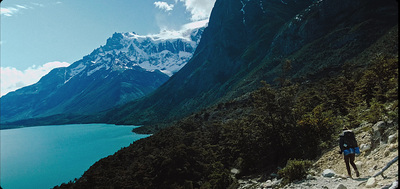 a man hiking up a mountain with a view of a lake