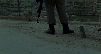 a man with a gun standing on a dirt road