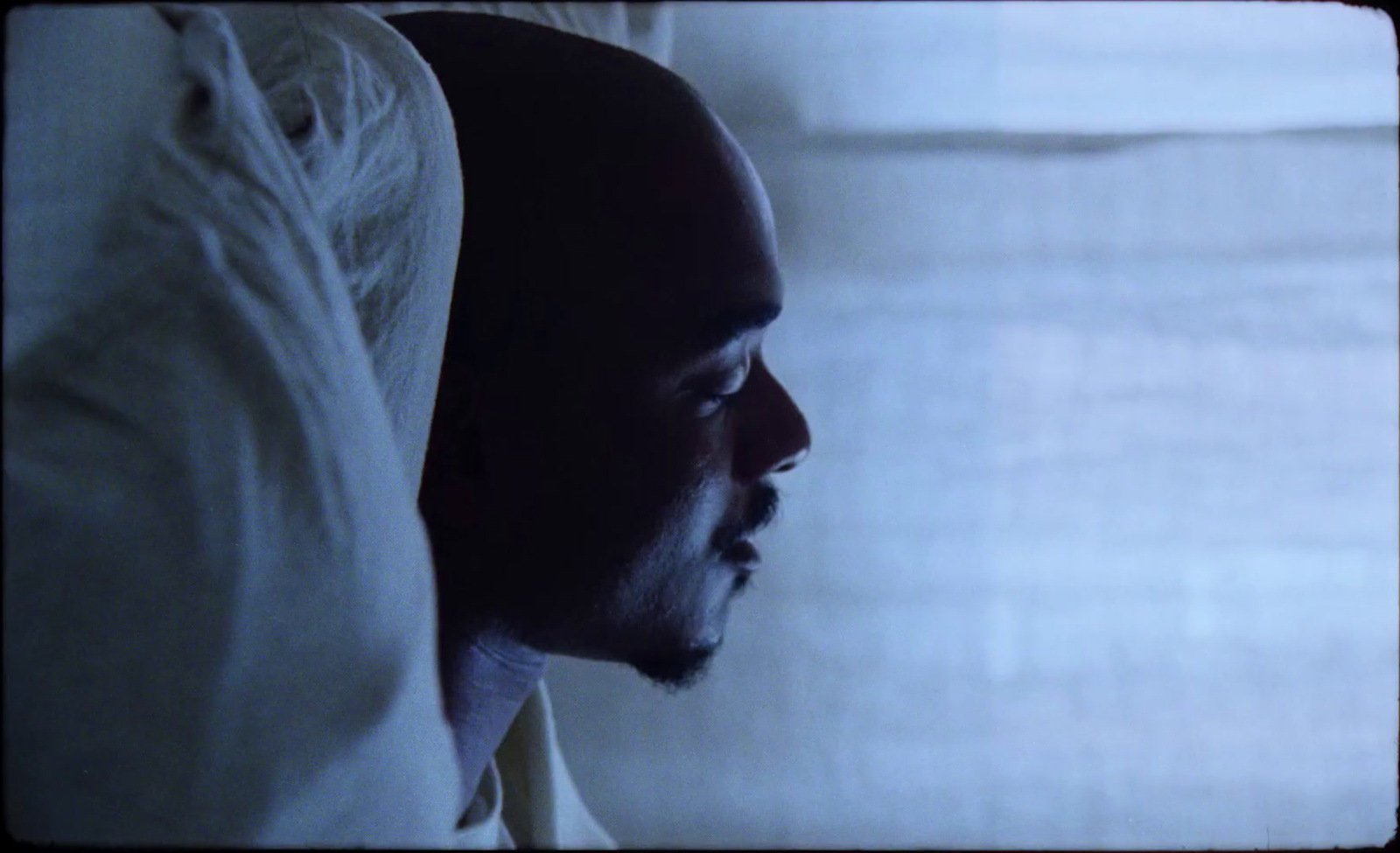 a man laying in bed with his head on the pillow