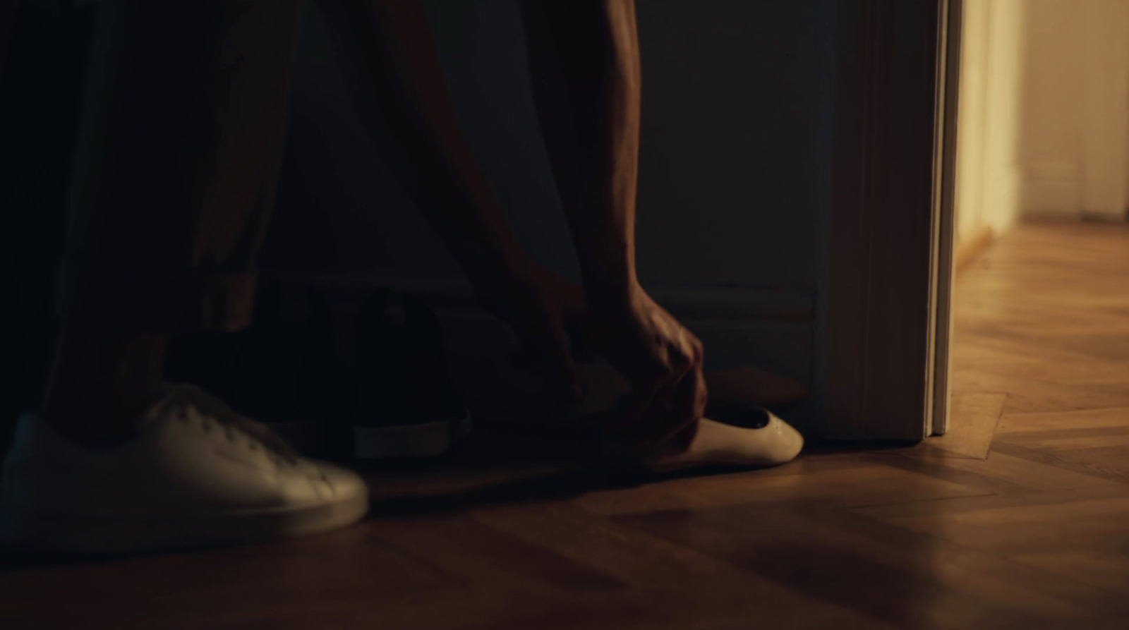 a person standing in front of a door wearing white shoes