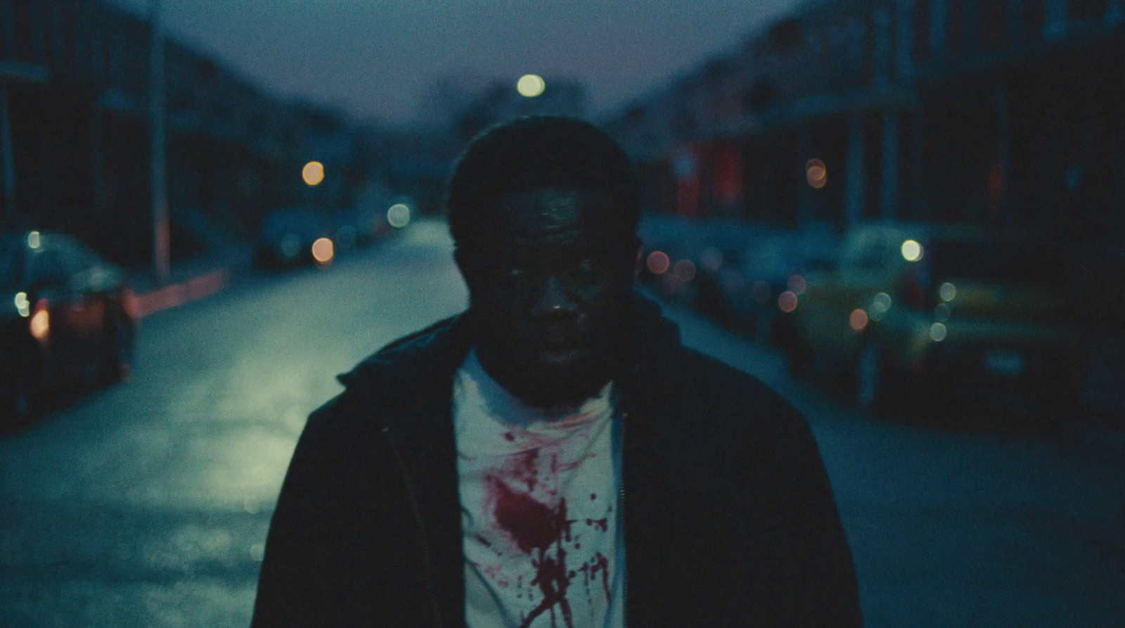 a man standing on the side of a street at night