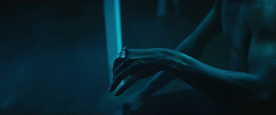 a woman's hand holding something in a dark room