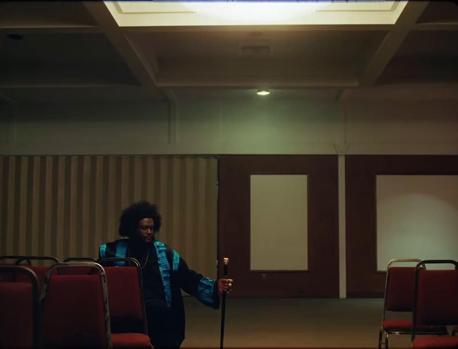 a woman standing in a room with red chairs