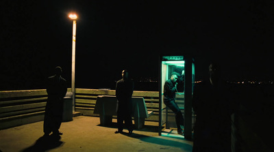 a group of people standing on a pier at night