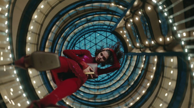 a man in a red suit is standing in a spiral staircase