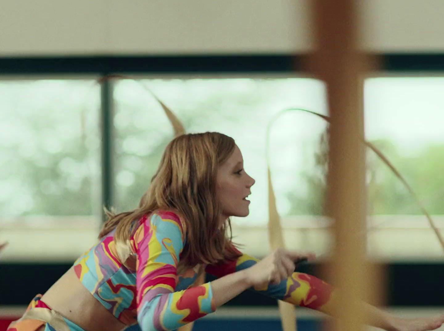 a woman in a colorful shirt is playing with a frisbee