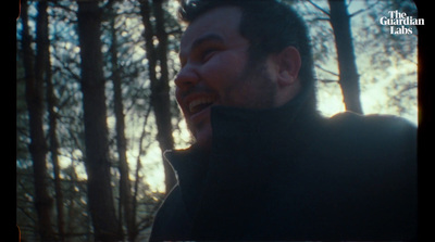 a man talking on a cell phone in the woods