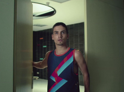 a man in a tank top standing in a hallway