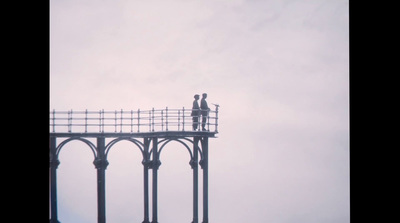 a couple of people standing on top of a bridge