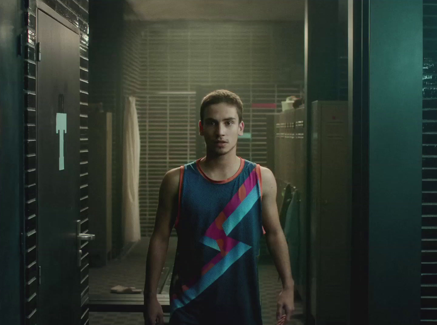 a young man standing in a hallway in front of lockers