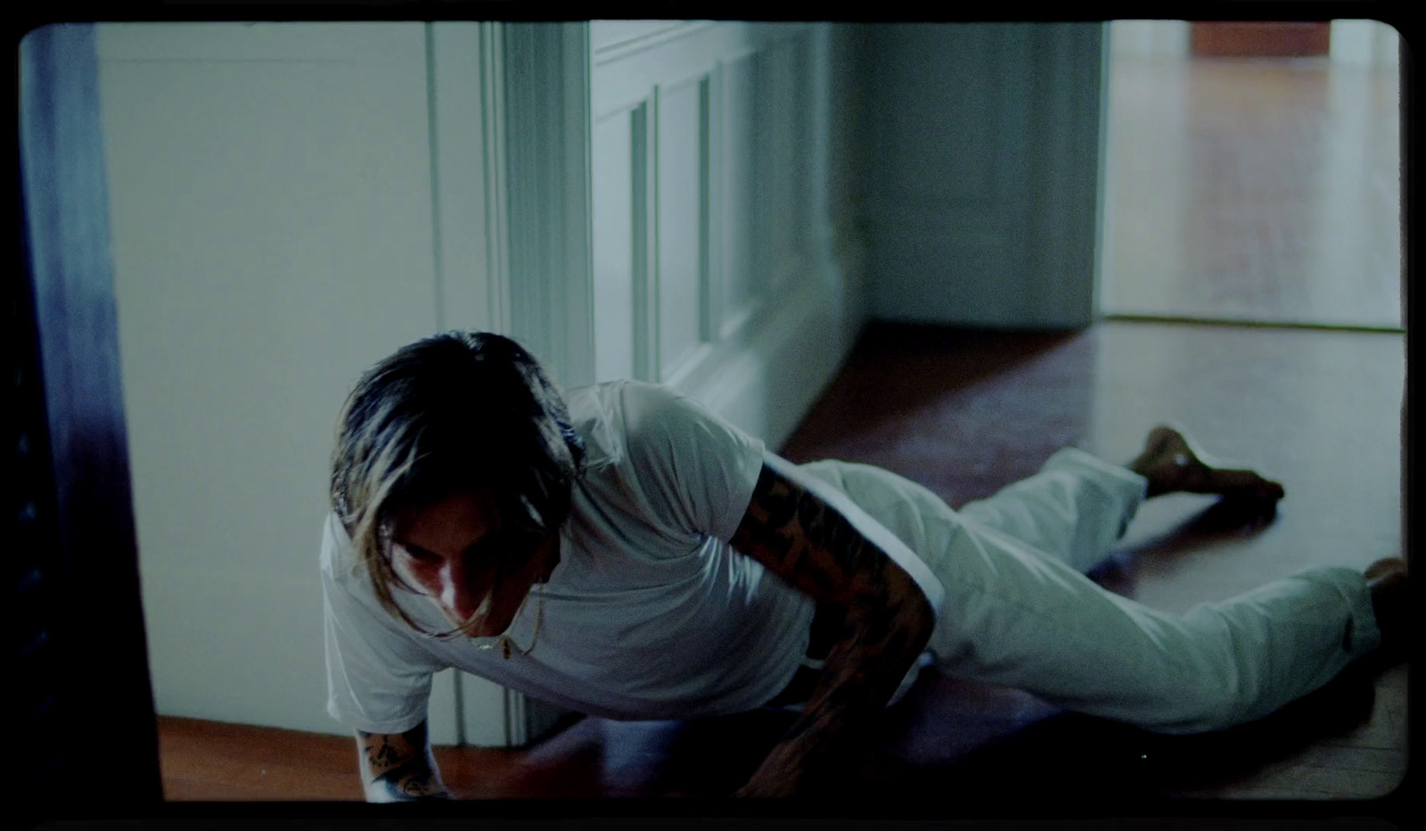 a man in a white shirt and white pants on the floor