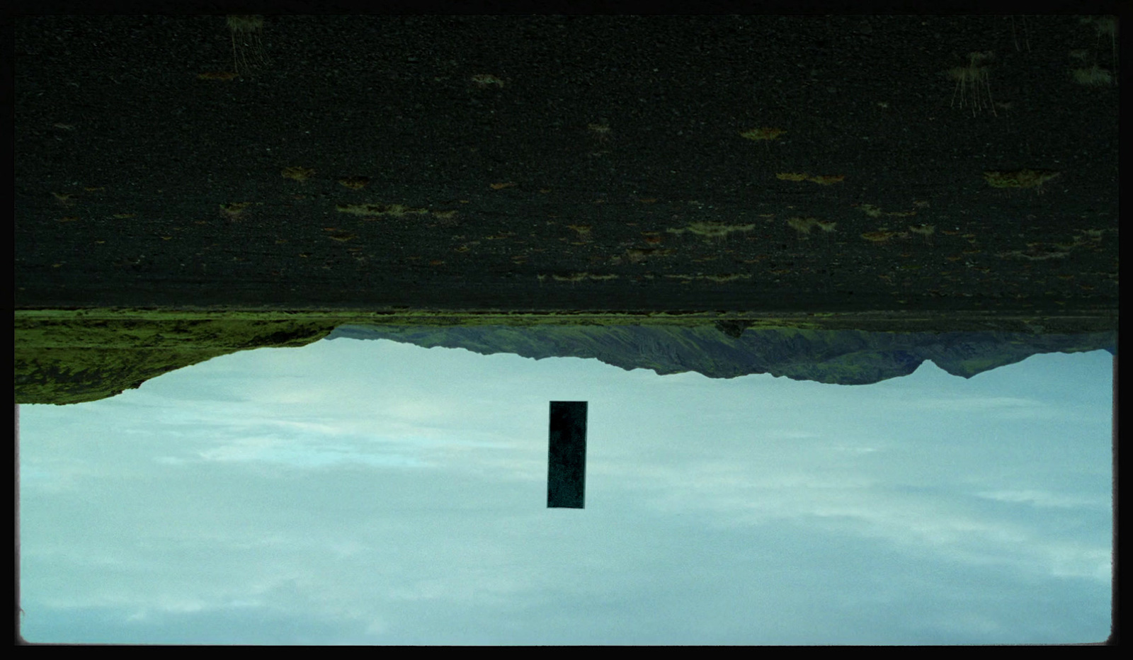 a reflection of a mountain in a pool of water