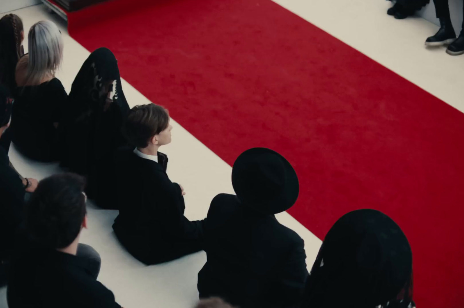 a group of people sitting on top of a red carpet