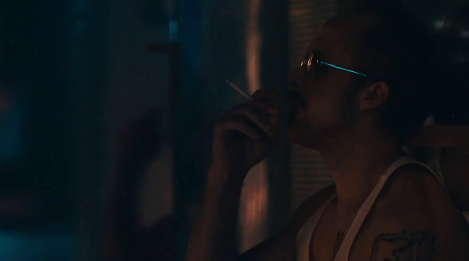 a man smoking a cigarette in a dark room