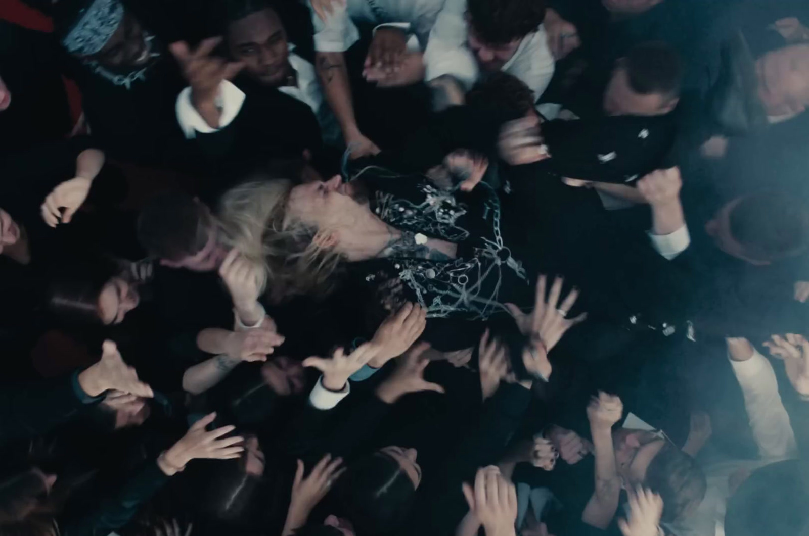 a crowd of people with their hands in the air