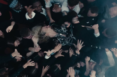 a crowd of people with their hands in the air