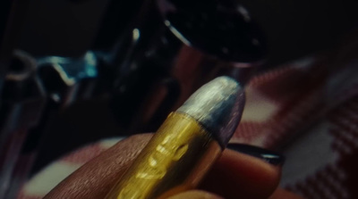 a close up of a person holding a bullet