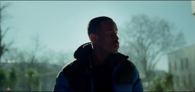 a man standing in front of a window with trees in the background