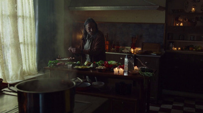 a woman standing in a kitchen preparing food