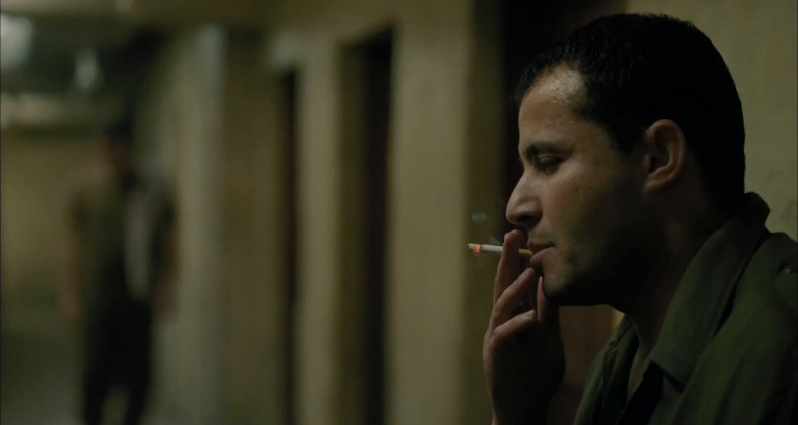 a man smoking a cigarette in a hallway