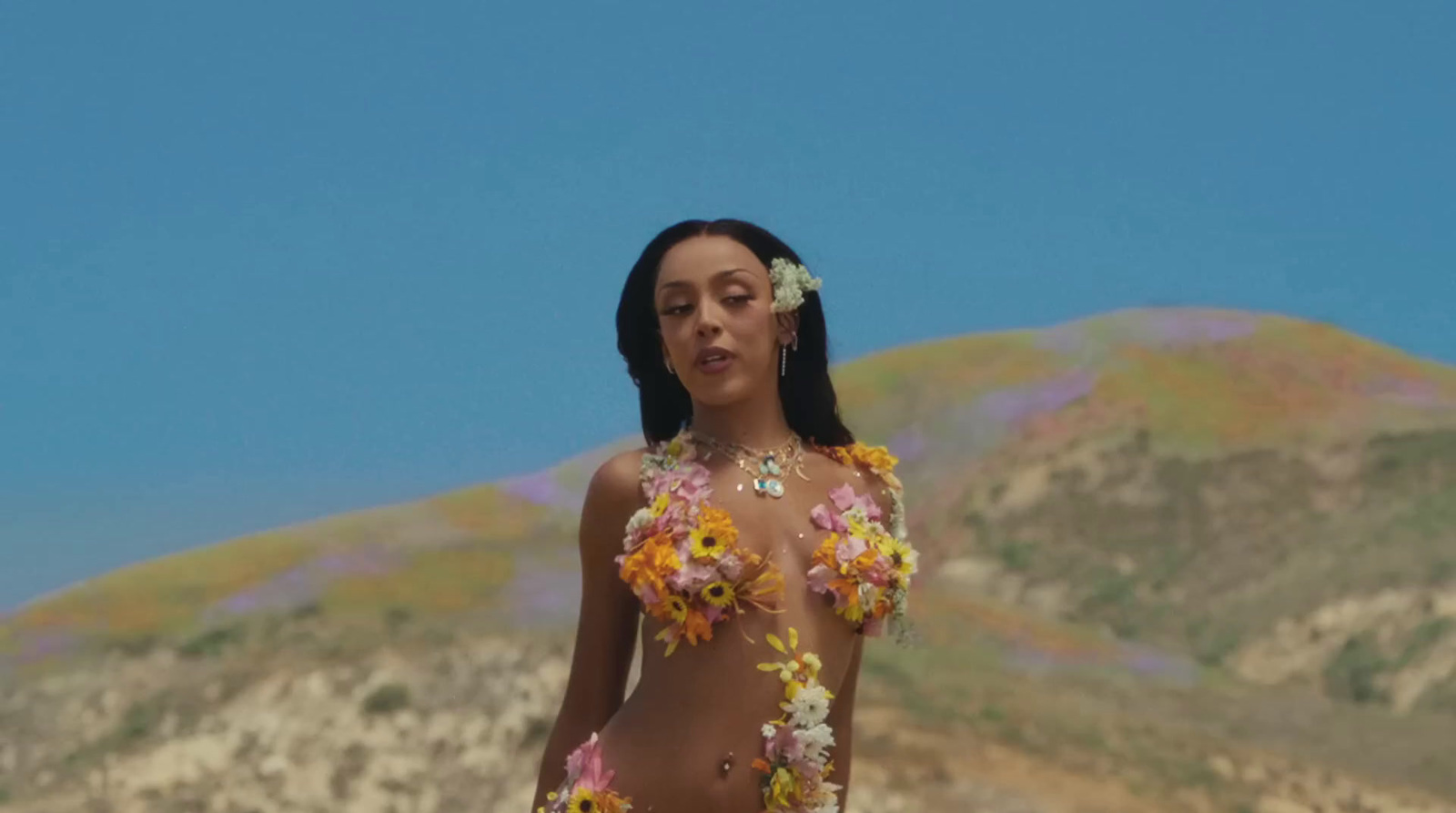 a woman in a bikini with flowers in her hair