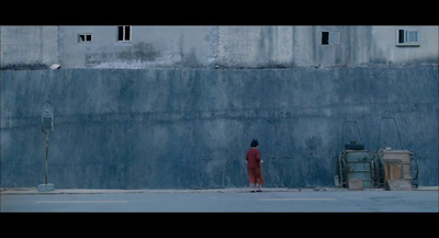 a man in a red suit standing in front of a wall