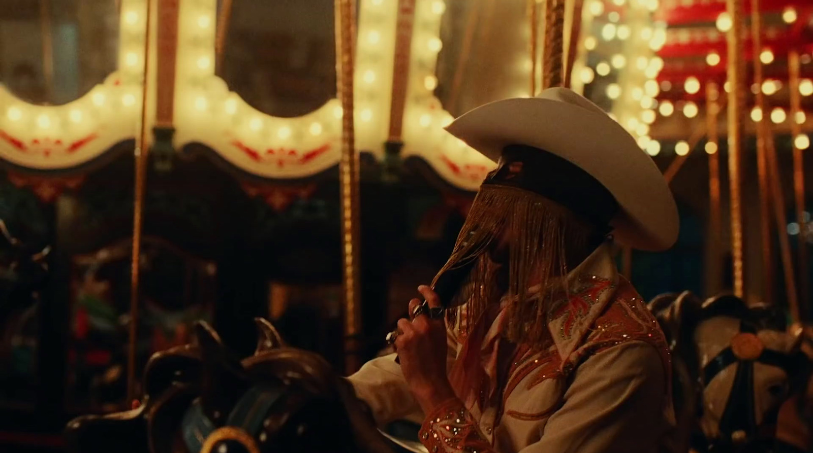 a man in a cowboy hat on a merry go round