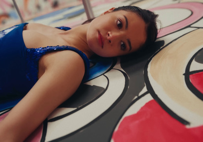 a woman in a blue bikini laying on a floor