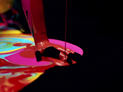 a knife sticking out of a colorful liquid puddle