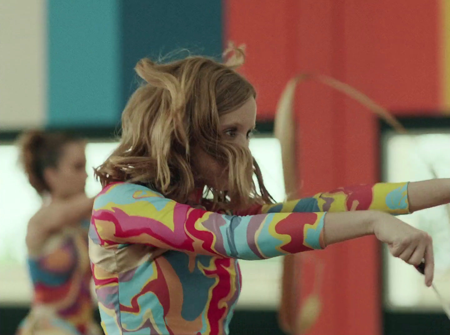 a woman in a colorful shirt is holding a bow