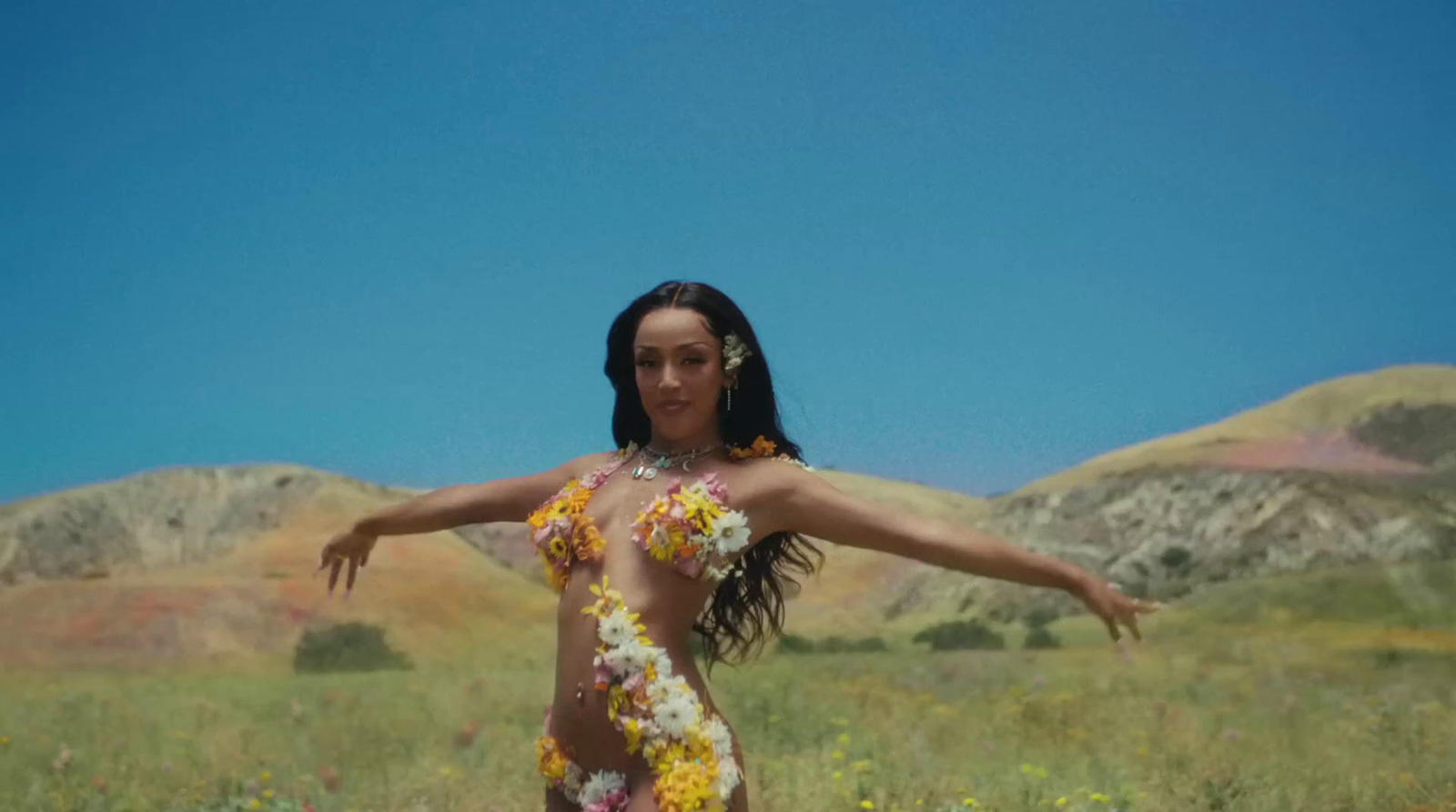 a woman in a flowered dress standing in a field