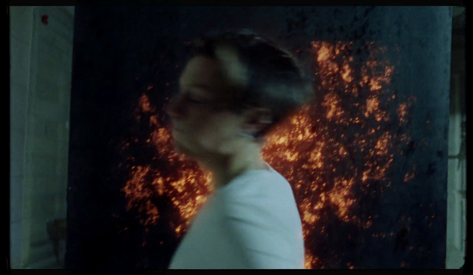 a man standing in front of a wall covered in fire