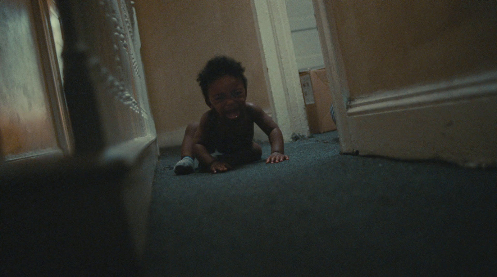 a young child crawling on the floor in a hallway